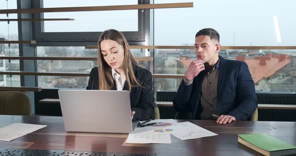 Thoughtful Man See How Woman Working in the Brightly Lit Modern Office