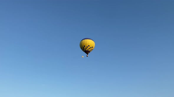 Colorful hot air balloons fly in the sunny morning blue sky. Maneuverable flight. Travel, adventure,