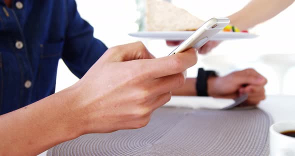 Man in lunch bar with smartphone and coffee