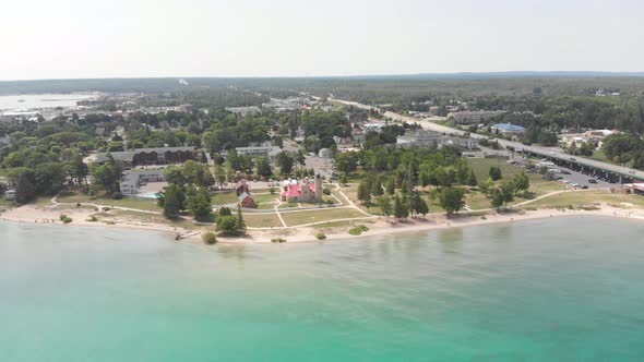 Aerial of Old Mackinac Point Lighthouse and surrounding beach in the beautiful summer turquoise wate