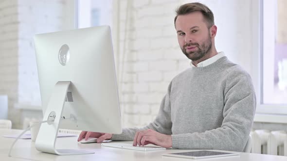 Smiling Man Looking Toward Camera at Work