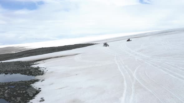 People Leisurely Riding Vehicles In Snowy Landscape Of Langjokull - aerial shot