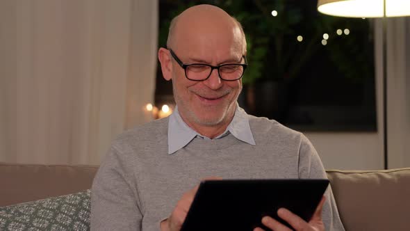 Happy Senior Man with Tablet Computer at Home