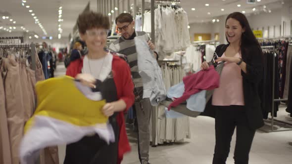 Happy People Having Fun while Shopping for Clothes