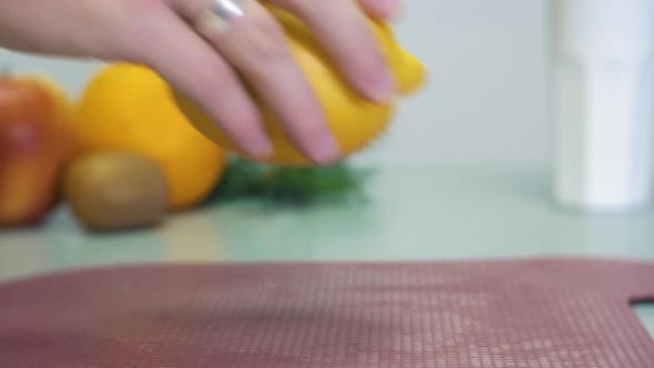 Man's hand puts the yellow lemon on the gray table on white background with fruits closeup slow moti