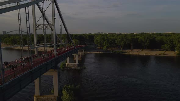 Huge Foot Bridge with Lots of People Walking to the Island Across the River