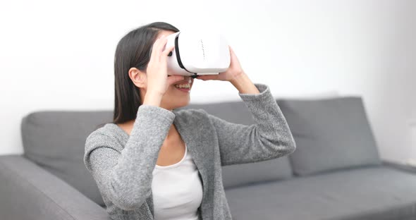 Woman look though virtual reality headset at home 