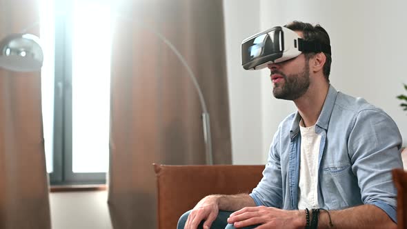 A Young Bearde Man Wearing VR Goggles