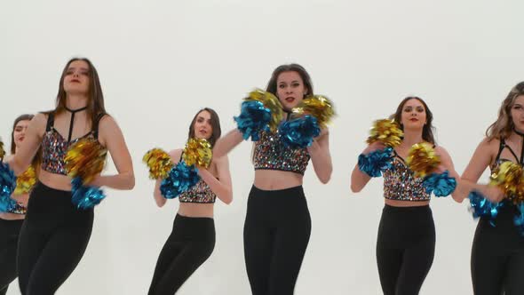 Group of Athletic Cheerleaders in Silver Tops and Black Tight Leggings are Dancing Cheering Dance on