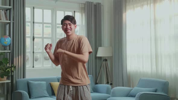 Asian Man Dancing While Shooting Video Content For Social Networks At Home