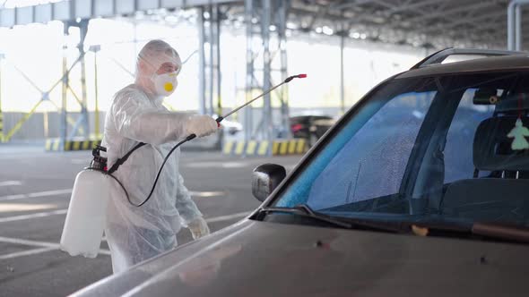 Man Dressed White Protective Overalls Spraying Vehicle Antibacterial Sanitizer Sprayer on Quarantine