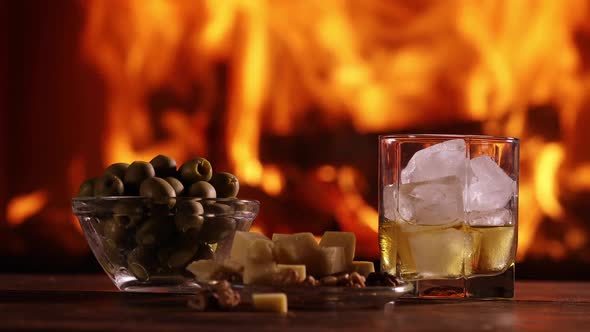 A Glass of Whisky And Plate With Cheese, Olives And Nuts