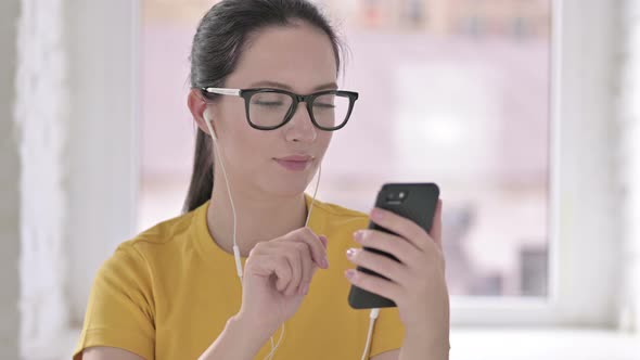 Portrait of Young Female Designer Listening Music on Head Phones