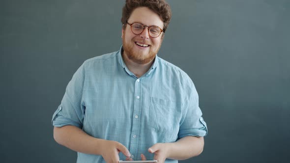 Portrait of Funny Guy Playing Smart Phone Video Game Kissing Device Smiling Looking at Camera