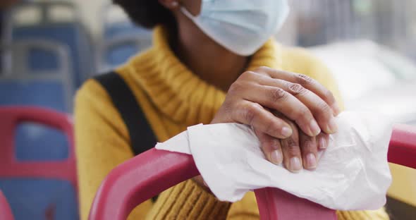 African american businesswoman with face mask sitting in bus