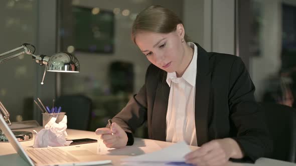 Young Businesswoman Working on Documents in Office at Night