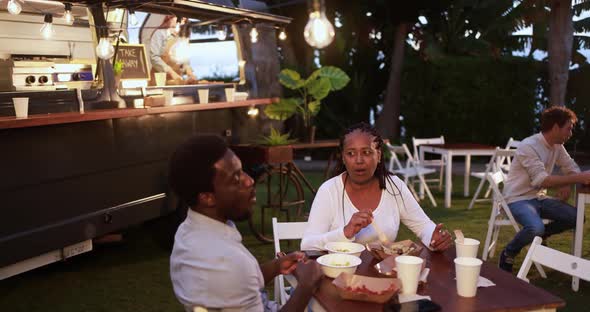 African mother and son eating food truck food outdoor - Family and summer concept