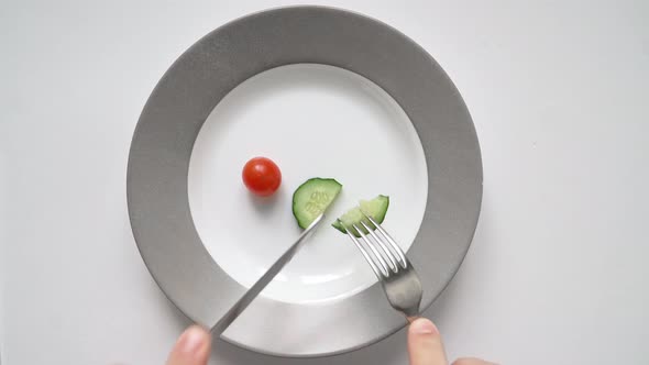 Man on Diet Eats Very Little Chili Tomato and Cucumber Plate