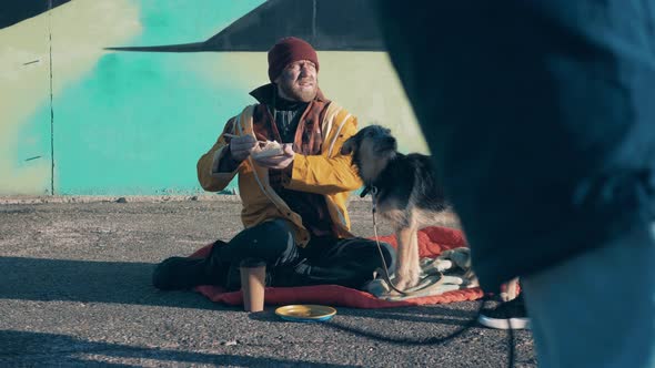 A Stranger Gives Money to a Homeless Man and His Dog