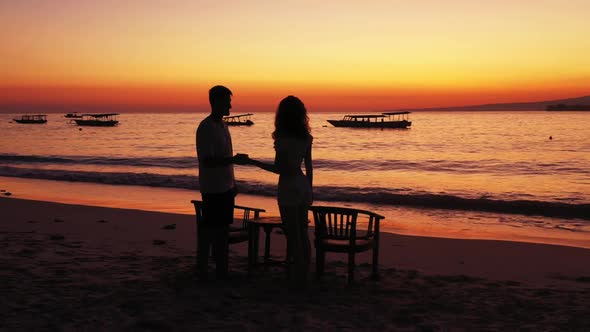 Man and lady tan on luxury resort beach holiday by blue green ocean and white sandy background of Gi