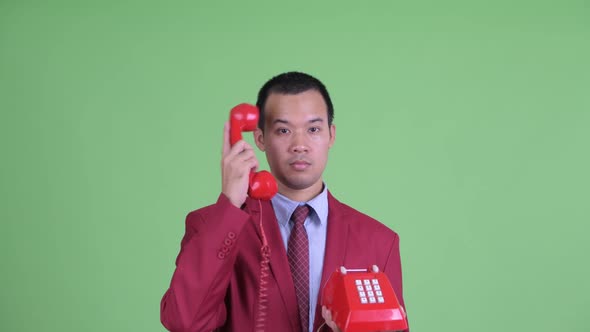 Face of Angry Asian Businessman Using Telephone and Shouting