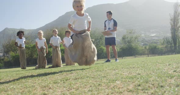 Children playing a sack race in park