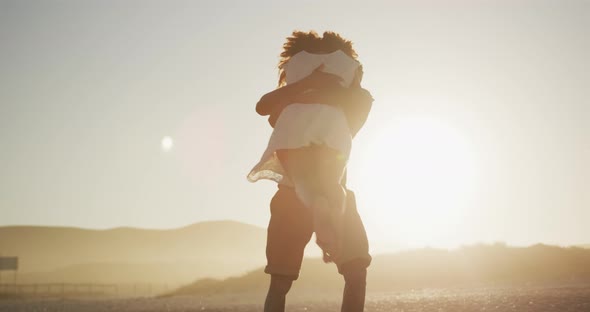 African American couple hugging at the beach