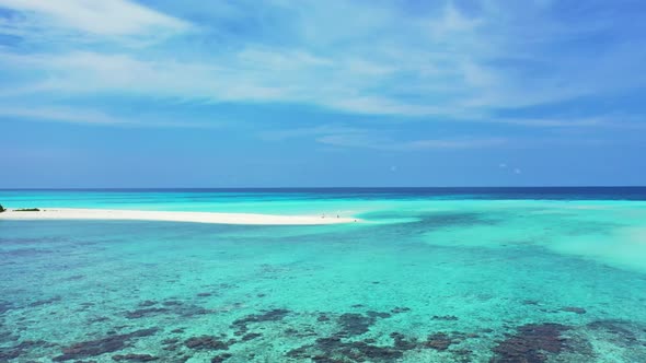 Aerial drone shot scenery of tranquil shore beach holiday by clear lagoon with white sand background