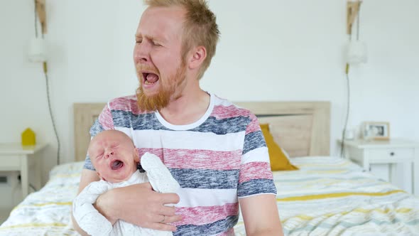 hysterical man with a crying baby in his arms in the bedroom