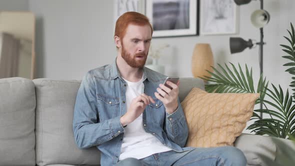 Astonished Man Shocked By Result on Smartphone Wondering