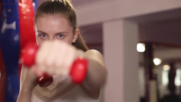 Girl Boxer Exercises Punches with Dumbbells in Hand