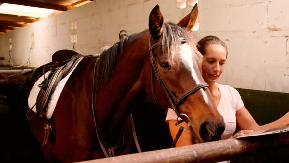 Woman standing with horse using laptop 4k