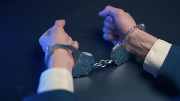 Arrested Criminal Businessman in Handcuffs in the Interrogation Room