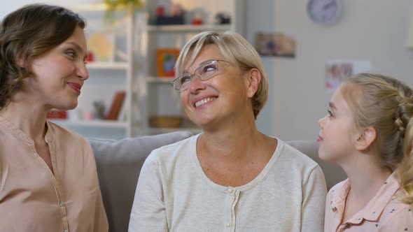 Cute Girl and Her Mom Kissing Granny, Family Embracing Heartily, Happy Together