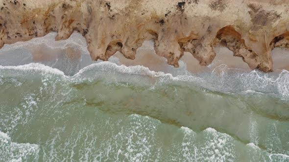 Aerial View of Stormy Waves Beating Against a Rocky Shore on a Sandy Tropical Beach