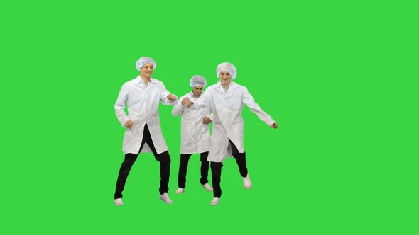 Three Male Doctors in White Robes and Protective Caps Running in the Frame and Start Doing Funny