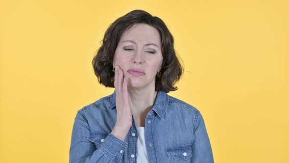 Old Woman with Toothache on Yellow Background 