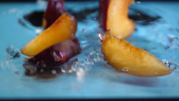 Slices of Ripe Plum Splashing Into Water