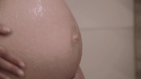 Close View of Pregnant Woman Washing Tummy Under Shower in Bathroom