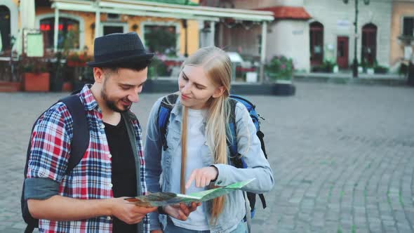 Trendy Couple of Tourists Finding Necessary Destination on Map and Admiring Surroundings