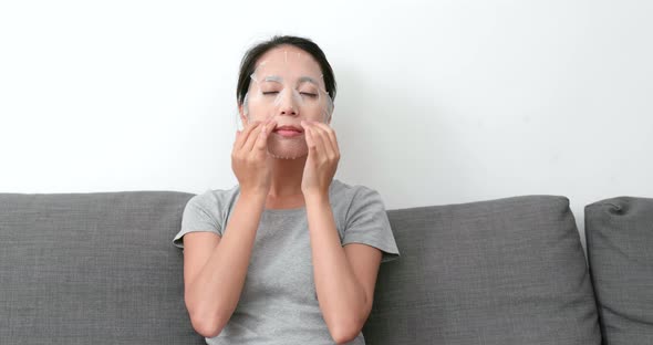 Woman apply paper mask on face