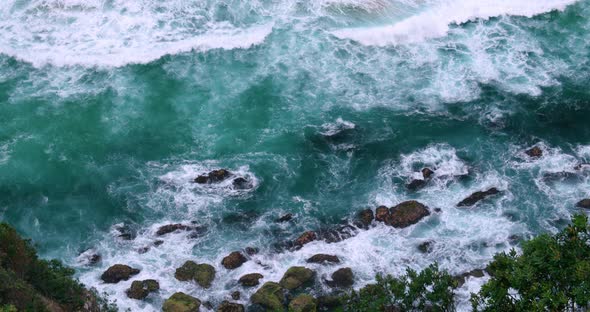 Foamy Waves Splashing Rocks At Byron Bay In New South Wales, Australia - aerial shot