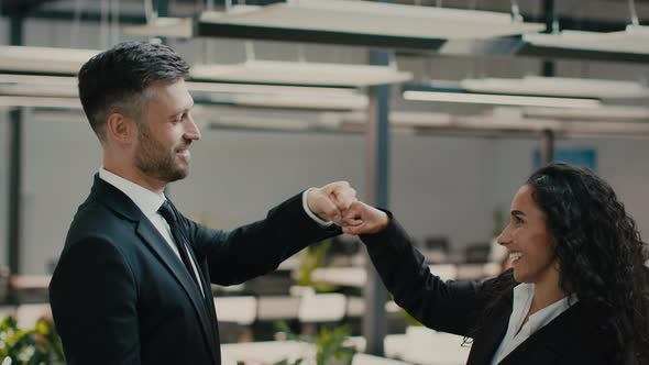 Male And Female Colleagues Making Fists Bump Standing In Office