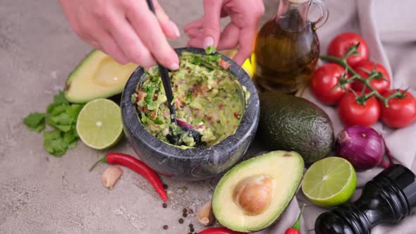 Making Guacamole Sauce  Woman Mixing Chopped Ingredients in Marble Bowl Mortar