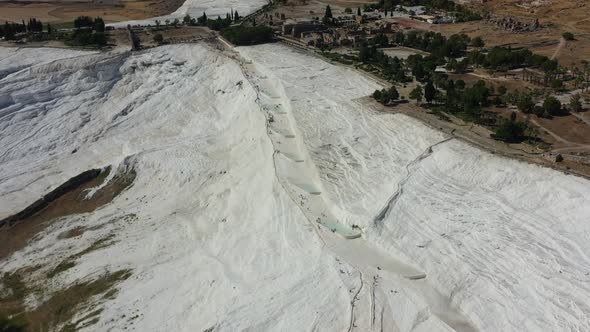 top down aerial view of tourists walking on the white mineral rich mountain hill where only a few th