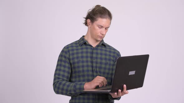 Handsome Hipster Man Thinking While Using Laptop