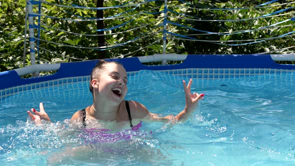 Happy Girl Child Swim in Outdoor Swimming Pool Showing v Sign Victory Hand Gesture Summer