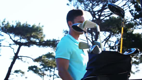 Golf player getting into golf buggy