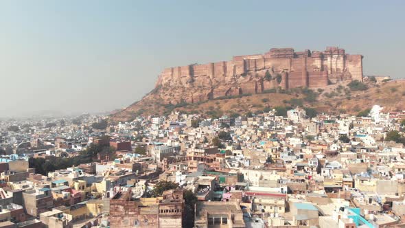 Blue City landscape of Jodhpur surrounding Mehrangarh Fort standing above cliff in Rajasthan, India