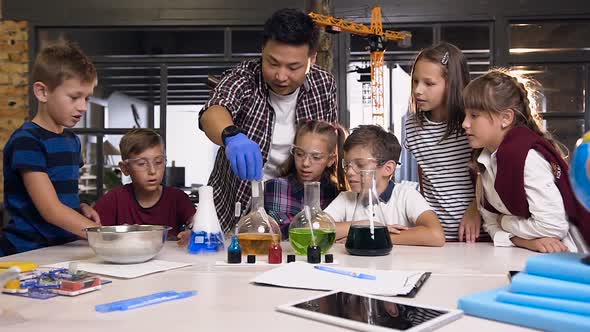 Asian Science Teacher with Kids in Lab Class Working About Experiment